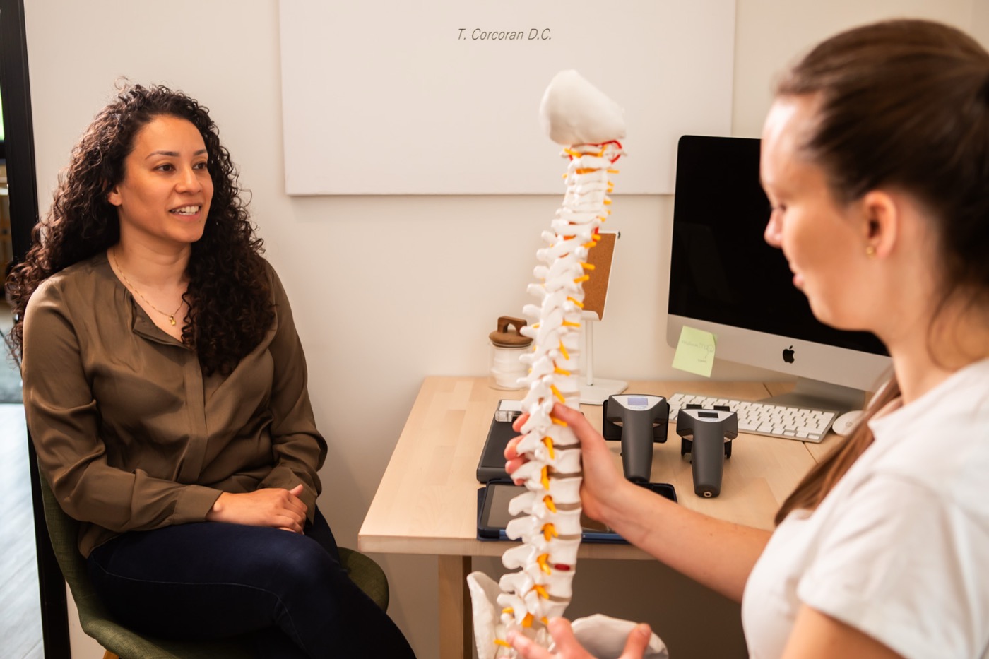 Chiropractor legt met een wervelkolommodel uit wat de scan laat zien bij TOPCHIRO Haarlem