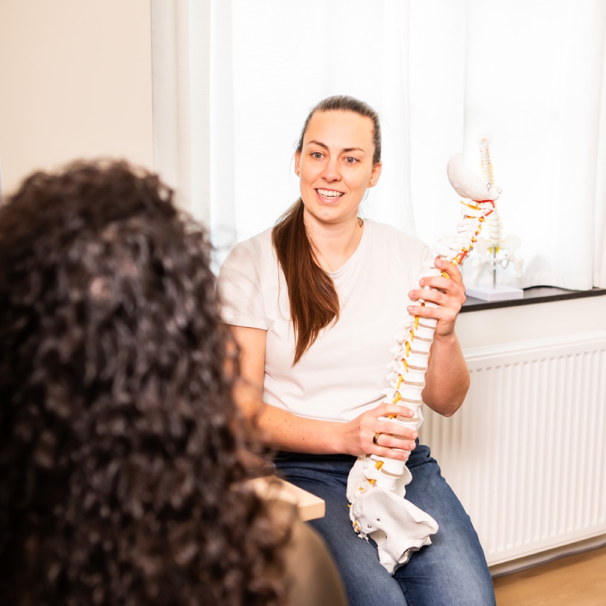 Chiropractor bespreekt het persoonlijke zorgplan met een cliënt bij TOPCHIRO Haarlem